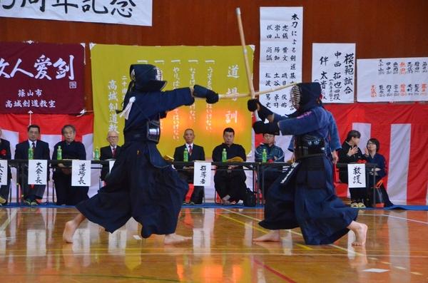 座ってみている来賓者の前で、選手が面打ちをしている写真